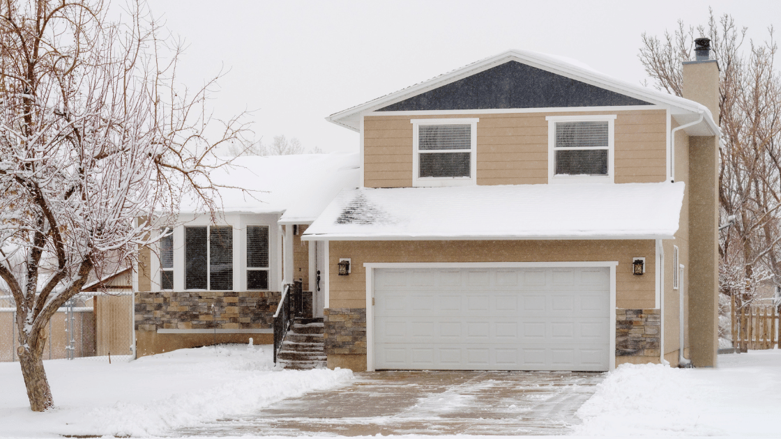 Snow-covered house with icicles hanging from the roof, depicting a chilly winter scene