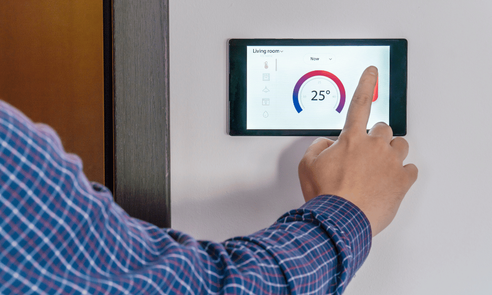 Home owner adjusting temperature with smart home thermostat