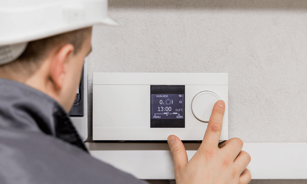 A HVAC Technician Adjusting a Thermostat